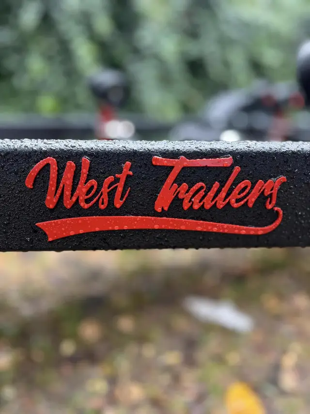 Czerwone logo West Trailers na czarnej ramie